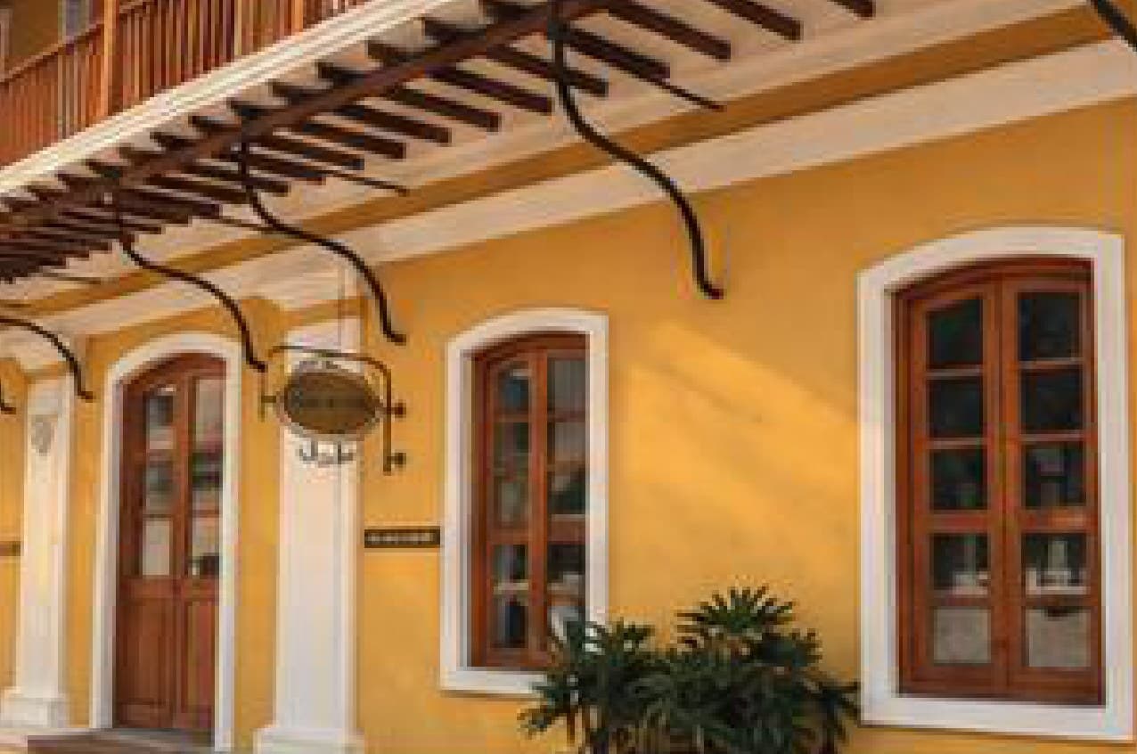 A mustard-yellow French colonial heritage building with wooden shutters in Pondicherry's White Town.