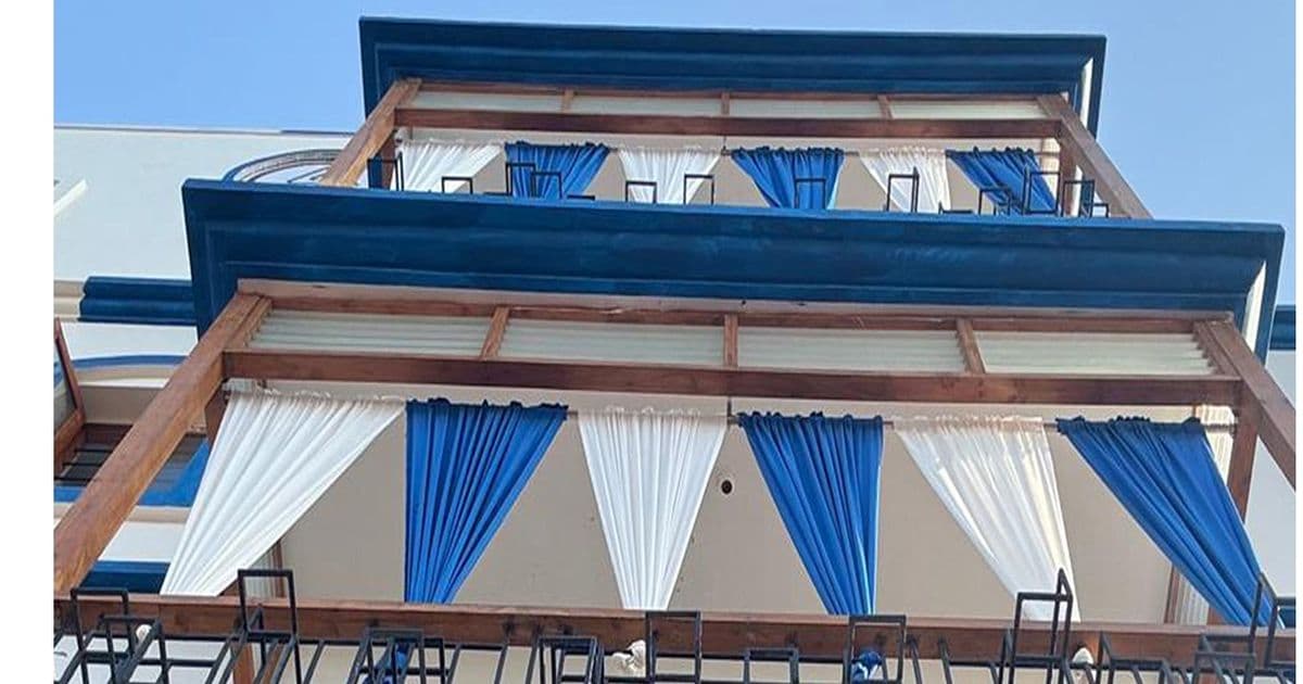 Auroma Phase IV — a terrace with a blue timber pergola and blue-and-white drapes.